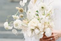 a white wedding bouquet in modern style, with trendy lunaria and some catchy detailing is a fresh idea