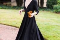 02 a black maxi dress with a pleated skirt, a plunging neckline and long sleeves, block heels and an animal print clutch, which is a trend