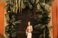 oversized wedding arch with lush tropical greenery