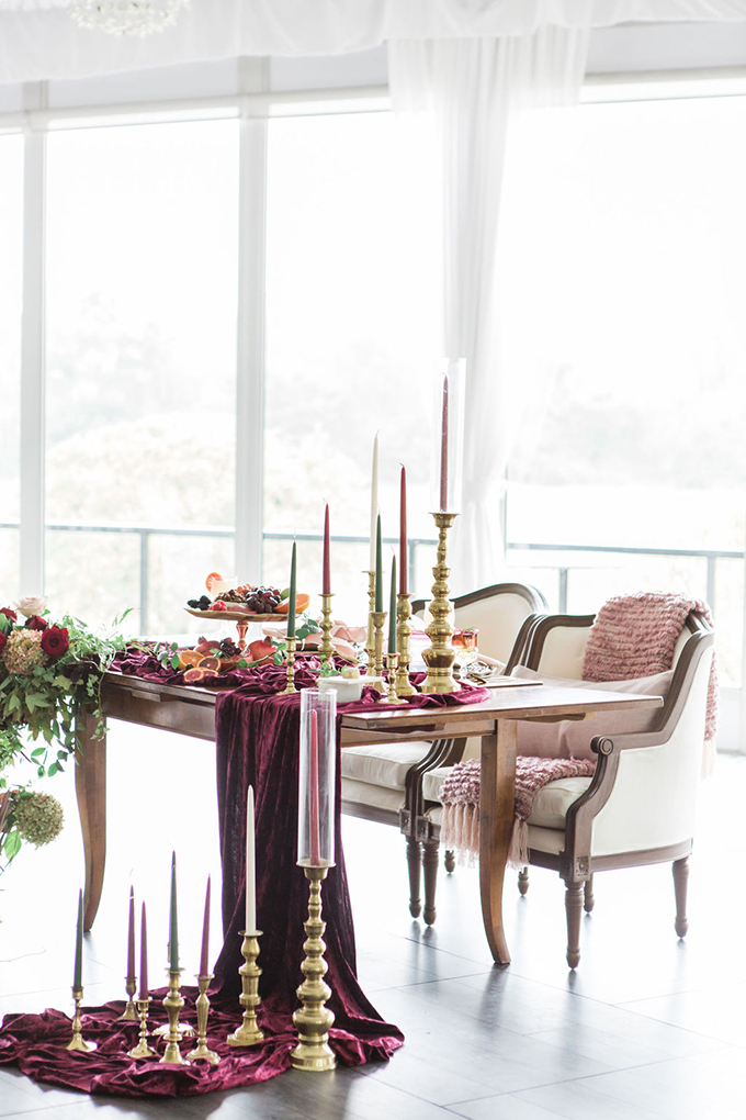 The wedding tablescape was done with purple velvet, gilded candleholders and colorful candles