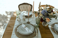 06 The table was done with woven placemats, elegant metallic candleholders and chic glasses