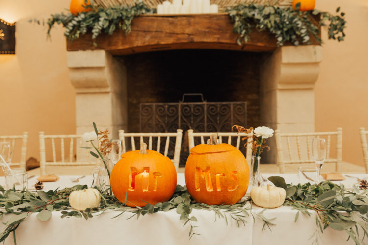 The reception table was decorated with pumpkins in orange and white, carved ones and greenery