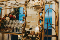 08 The wedding drink bar was styled with a refined mirror and a refined and chic stand for glasses