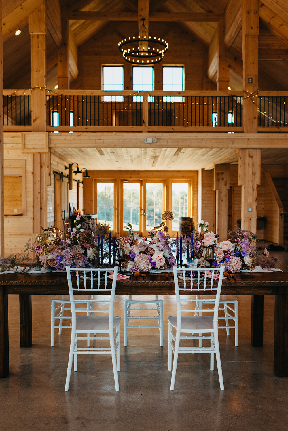 The wedding reception strikes with lush florals at once, and deep colored candles complete the look