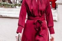 09 a burgundy knee dress with a high neckline, long sleeves, an animal print clutch and statement earrings