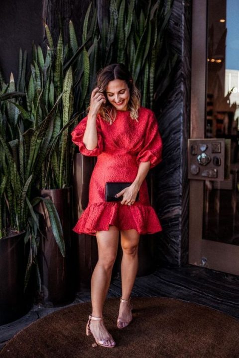 a short red dress with long puff sleeves, a high neckline, a playful skirt and nude shoes and a black clutch
