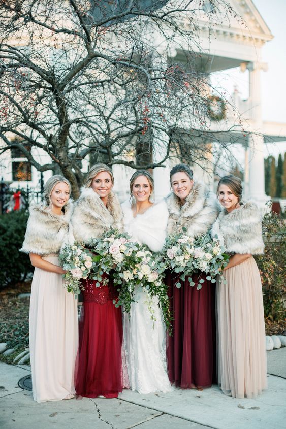 deep red and neutral bridesmaid dresses with neutral faux fur coverups are chic and cool