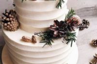 22 a buttercream wedding cake decorated with fir, pinecones, nuts and cinnamon sticks looks trendy and modern