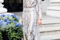 a NYE wedding guest outfit with a sequin A-line midi dress with a high neckline, blue velvet shoes and statement earrings