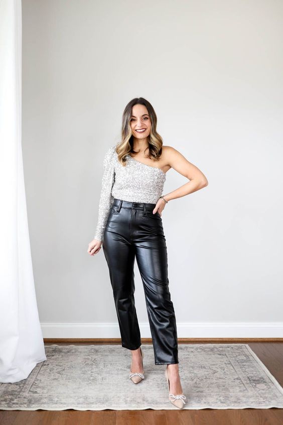 a NYE wedding guest outfit with black leather pants, a silver sequin one shoulder top, nude shoes with bows