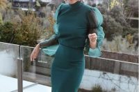 a beautiful and refined hunter green fitting midi dress with puff sleeves, a turtle neckline, statement burgundy earrings