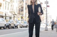 a black pantsuit with no top under, a metallic bag and black heels for a sexy look at a more formal wedding