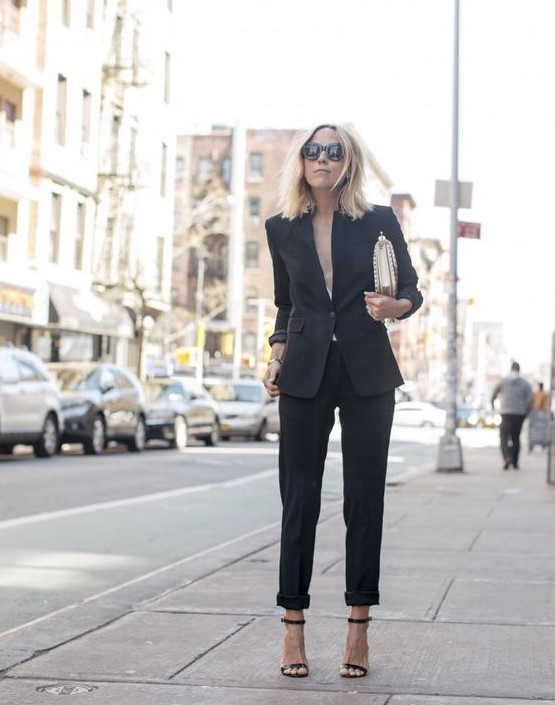 a black pantsuit with no top under, a metallic bag and black heels for a sexy look at a more formal wedding