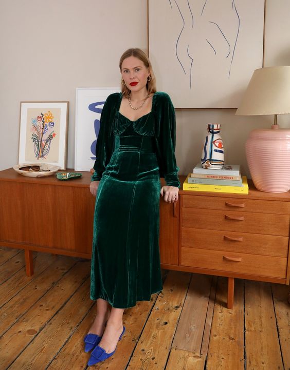 a bold Christmas wedding guest look with a dark green velvet midi dress, long sleeves, bold blue shoes
