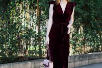 a bold and chic burgundy velvet midi wrap dress with cap sleeves, pink suede strappy shoes and a pink bag