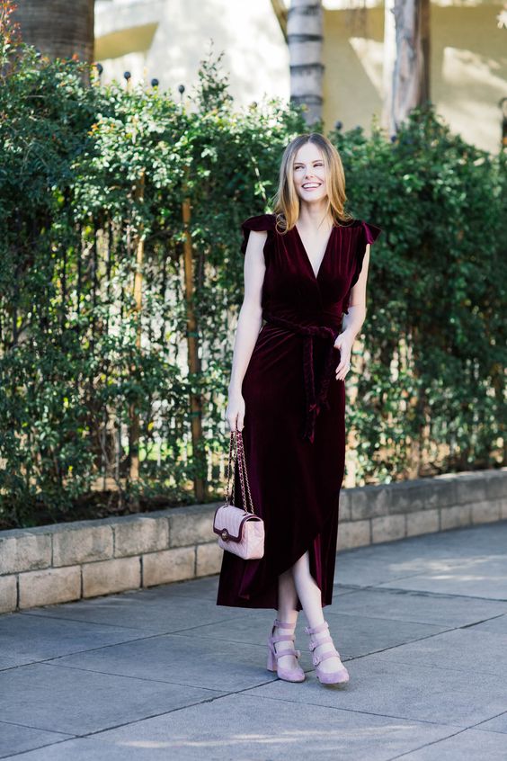 a bold and chic burgundy velvet midi wrap dress with cap sleeves, pink suede strappy shoes and a pink bag