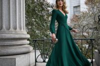 a bold green maxi dress with a deep V-neckline, long sleeves, a small embellished clutch bag for a Christmas wedding