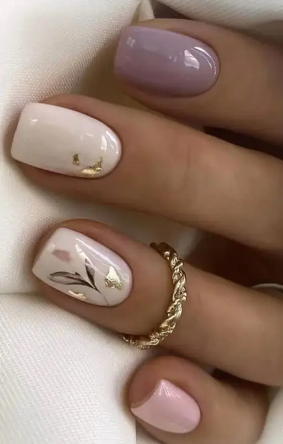 a catchy spring manicure with a lilac, creamy and pink nail, with gold foil and painted blooms is wedding-worthy
