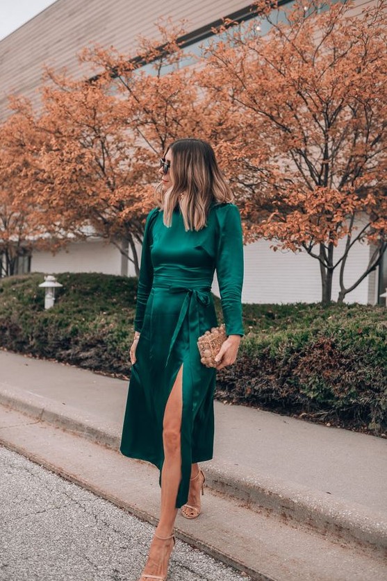 a dark green midi dress with a front slit, a high neckline, long sleeves, nude shoes and an embellished box clutch