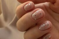 a delicate and beautiful wedding manicure with gold polka dots and small splatters is chic for spring or summer