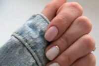 a delicate and pretty wedding manicure with blush and white nails and a touch of gold glitter at the bottom of the nail