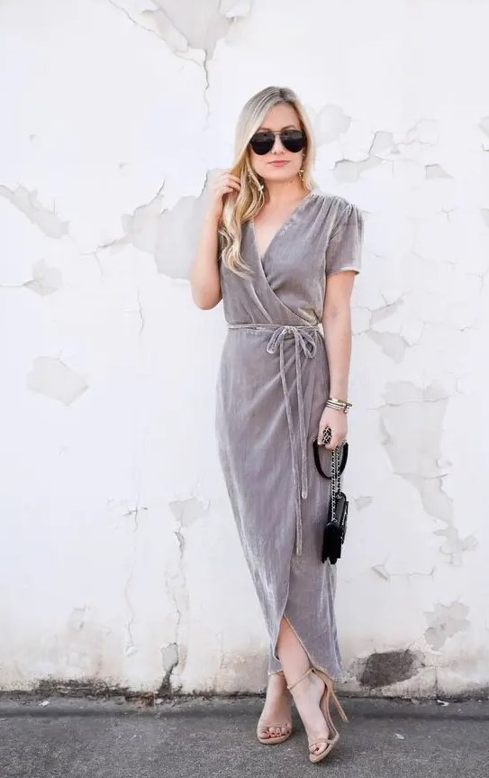 a grey wrap velvet dress with long ties, short sleeves, nude heels and a small black bag