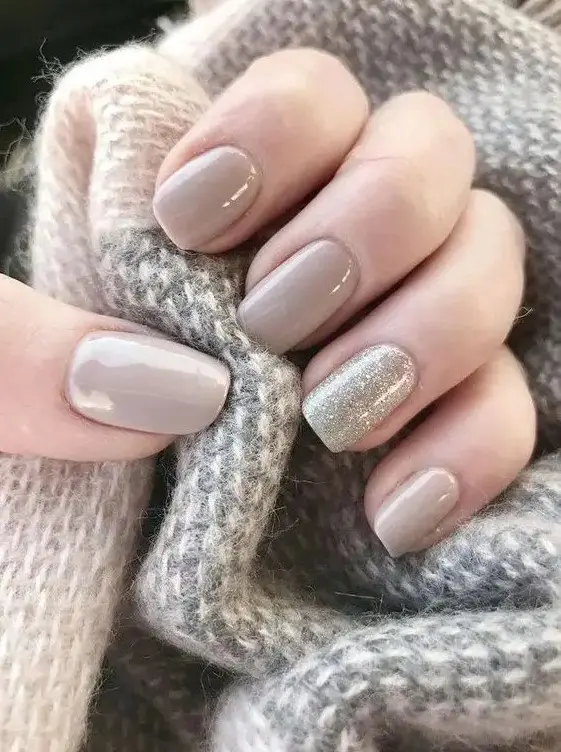 a light grey manicure and a silver glitter accent nail compose a stylish glam manicure for a winter bride