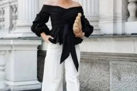 a monochromatic look with an off the shoulder black draped blouse, white wideleg pants, black heels and a woven clutch