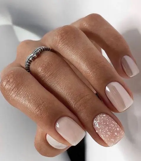 a neutral wedding manicure with blush, dusty pink and milky nails and an accent nail with glitter is a very chic and cool idea