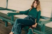 a pretty fall or winter wedding guest look with an emerald turtleneck, velvet wideleg pants, grey polka dot shoes and a small velvet bag