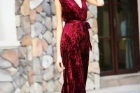 a red velvet belted jumpsuit with no sleeves and a sash is a gorgeous idea for a fall or winter wedding