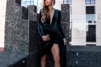 a sophisticated Christmas wedding guest look with a dark green high low velvet dress with a plunging neckline and nude shoes