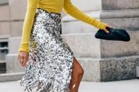 a sunny yellow turtleneck, a silver fringe skirt, a chain necklace, yellow snakeskin print shoes and a black clutch