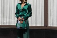 an emerald look with a blouse and flare pants, a stripe bag is a cool and chic idea for a Christmas wedding