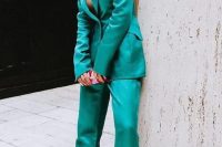 an emerald pantsuit with a long blazer, pants, pink shoes and statement earrings is a catchy look to rock