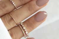 beautiful shiny mauve wedding nails plus multiple midi rings to accent the manicure are a lovely and cool idea for a wedding
