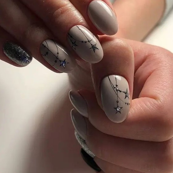 blush starry night manicure with silver stars and silver accent nails for a winter or a starry night wedding