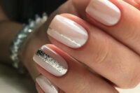 creamy nails with silver glitter stripes on some of them for a modern romantic look