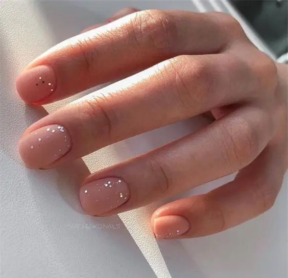 matte nude wedding nails with gold foil sprinkles are a fantastic idea for a wedding, they look glam and chic
