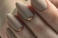 matte off-white bridal nails with a touch of gold glitter on two of them are very chic and stylish