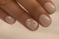 milky wedding nails with a ring finger nails done with marble effect and gold leaf are gorgeous for a bride
