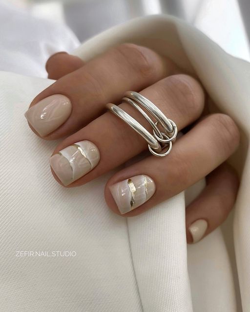 nude marble nails with gold foil touches are amazing for a wedding, they will fit a glam bridal look
