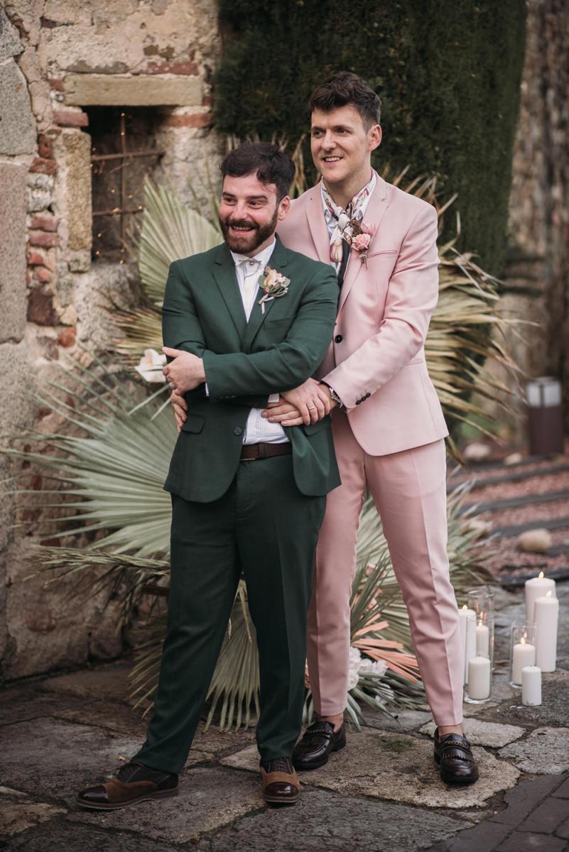 The grooms were wearing stylish outfits   a green and a pink suit with a tropical print shirt and chic moccasins