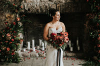 03 The bride was wearing a chic strapless lace sheath wedding dress with a train and carrying a red and pink wedding bouquet