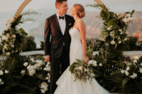 03 The wedding arch was a round one with lush tropical greenery and white blooms and a gorgeous view