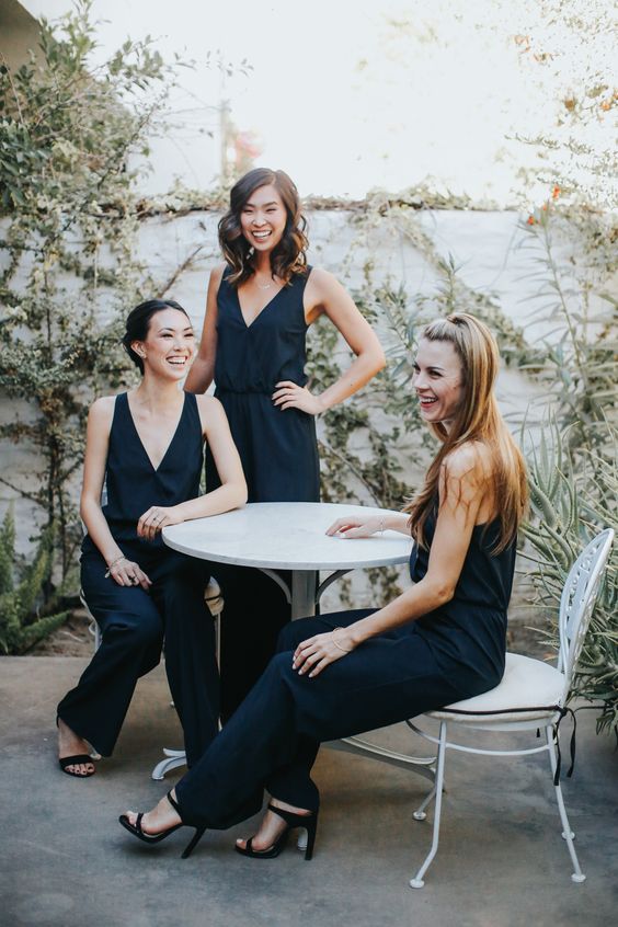 stylish and simple navy modern jumpsuits with deep V necklines and black heels for modern bridesmaids