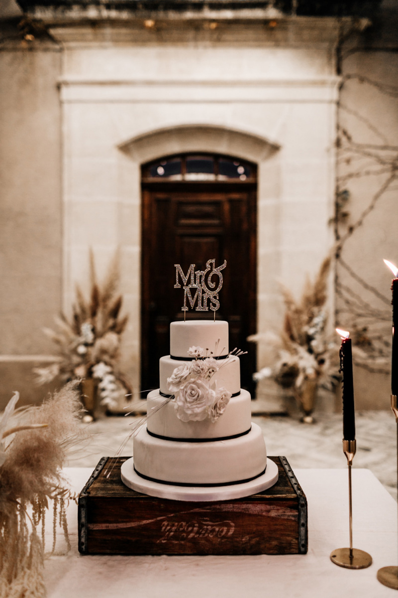 The wedding cake was white, with black ribbons and white sugar blooms