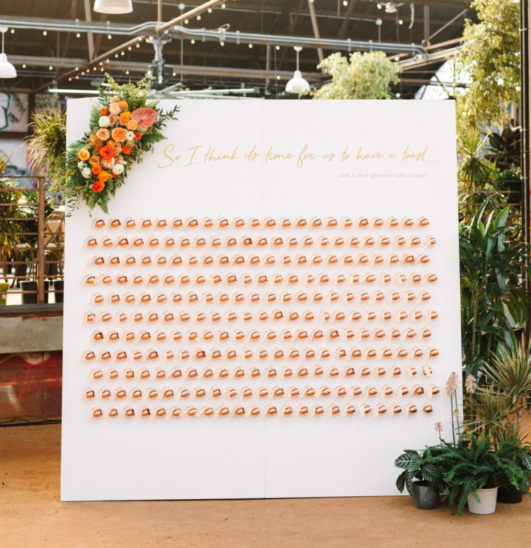 The wedding escort card display was done with copper mugs that doubled as favors