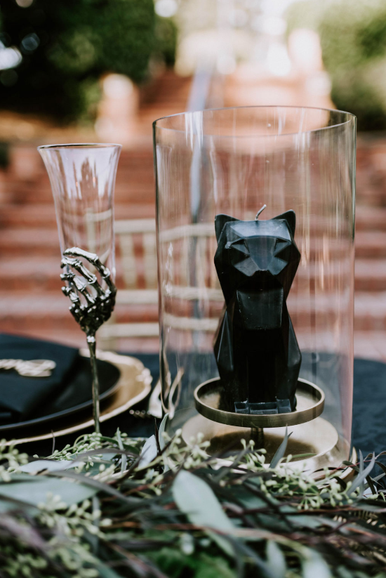 Some whimsy details skeleton hand glasses and black cat candles added to the ambience