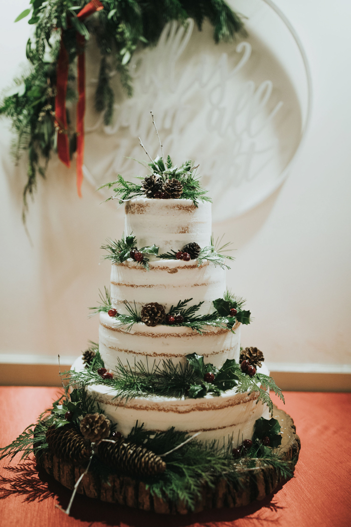 The wedding cake was a naked one, with greenery, pinecones and cranberries